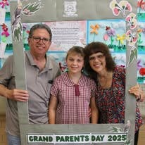Grandparents with grand daughter holding frame